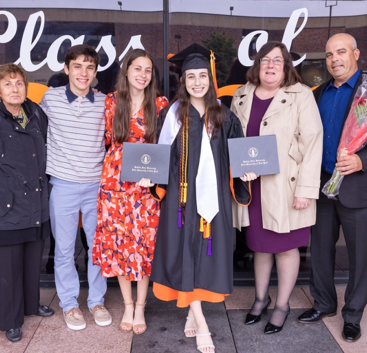 Family surrounds graduating student showing diploma